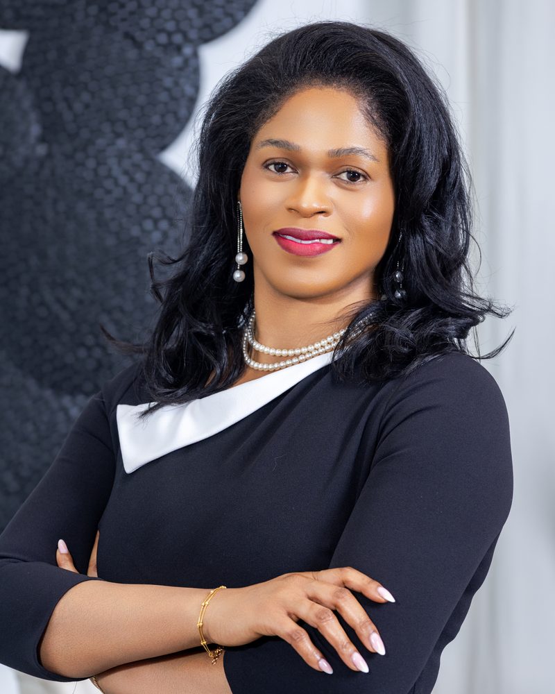 Blanche Kalala, digital transformation and Agile coach, in a black dress with a white collar, arms crossed